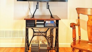 Un téléviseur fixé sur un support en bois, avec un jeu d’échecs posé sur le dessus.