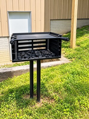 A barbecue grill with charcoal on a stand in front of a building. - The Meadow Lodge- Cozy 3BR Farm Barndo with Fire Pit and nearby Wedding Venues  (White Hall)
