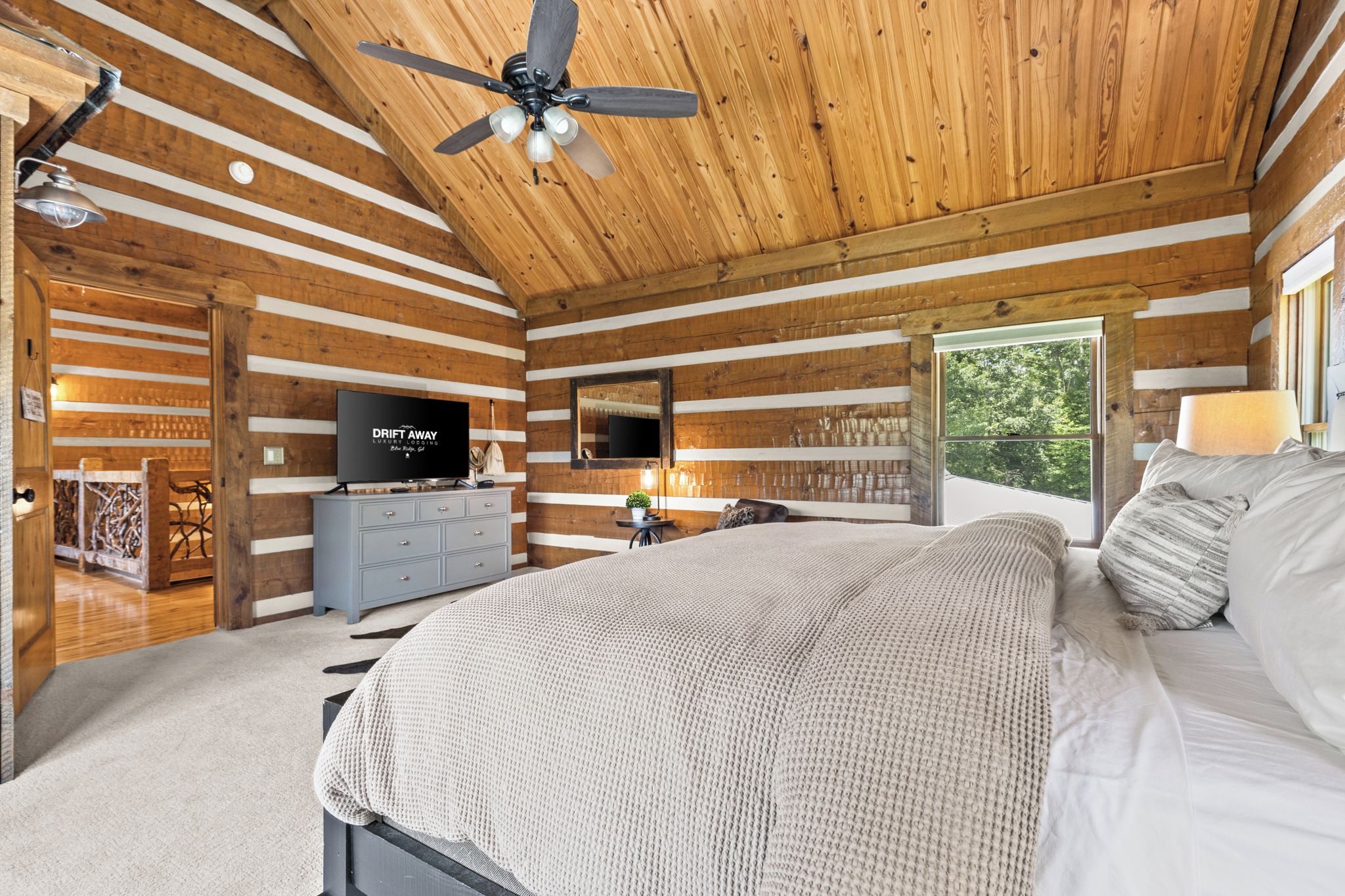 Une chambre confortable avec un lit, une télévision et un ventilateur de plafond.