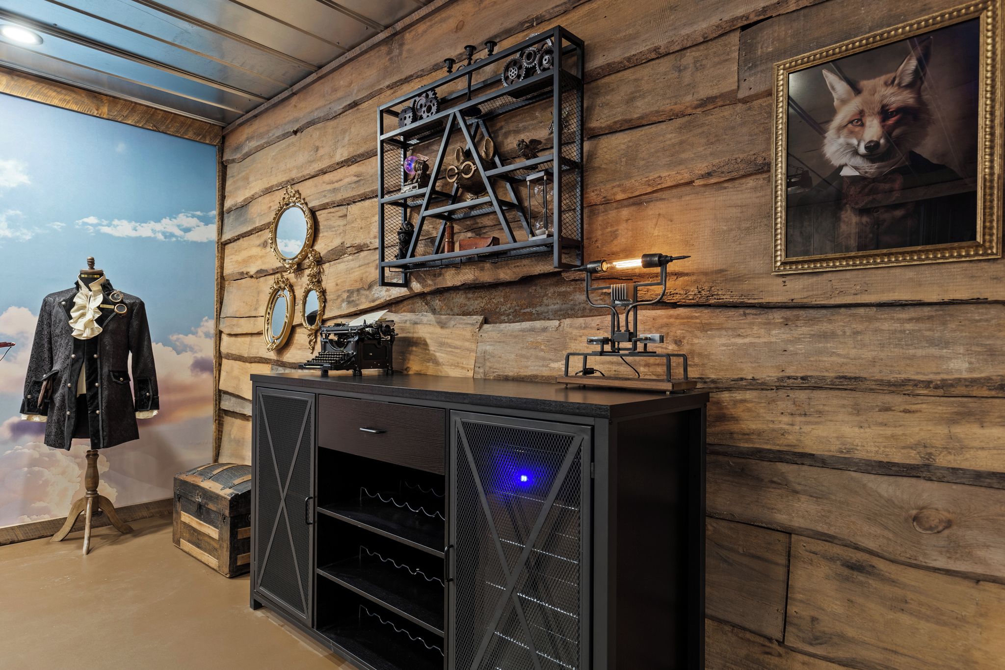 Una habitación con pared de madera, un maniquí con abrigo negro, una máquina de escribir antigua y un cuadro con la imagen de un zorro.