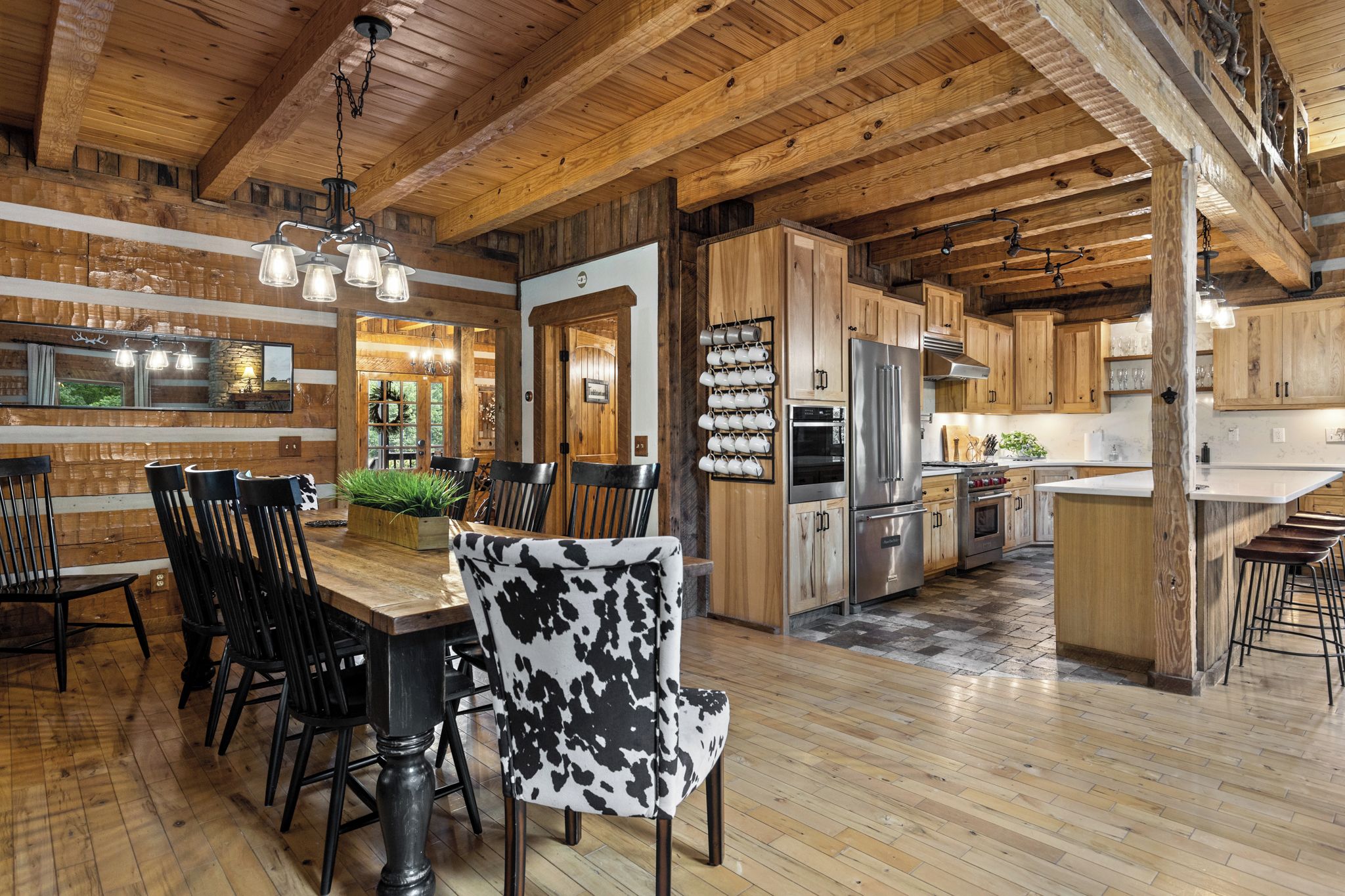 Un intérieur rustique avec un coin repas en bois, une cuisine et un bar.