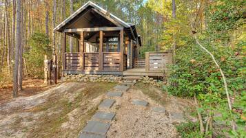 Eine Holzhütte mit Veranda, Steinstufen und einer Holzterrasse.