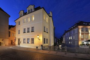 A historic building with a classic European architectural style, featuring a prominent entrance and a well-lit facade. - Certovka Hotel (Prague)