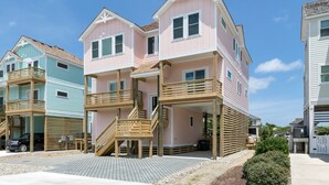 Una hilera de casas de playa con balcones de madera y un cielo despejado.