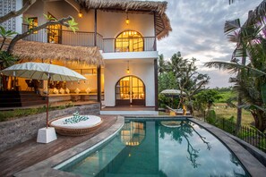A two-story house with a pool, outdoor seating, and a thatched roof. - Tropical Private Villa, 3 BR, Canggu Ricefield View (Canggu)