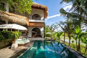 A poolside area with a thatched-roof building, a lounge chair, and a view of a water body. - Tropical Private Villa, 3 BR, Canggu Ricefield View (Canggu)