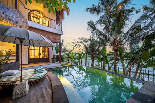 A two-story building with a pool, outdoor seating, and tropical vegetation. - Tropical Private Villa, 3 BR, Canggu Ricefield View (Canggu)