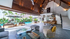 A spacious living area with a pool, outdoor seating, and a staircase leading to an upper level. - Splendid Private Villa, 4 BR, Canggu With Staff (Pererenan)
