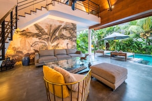 A modern living room with a glass coffee table, sofas, and a staircase. - Splendid Private Villa, 4 BR, Canggu With Staff (Canggu)