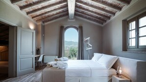 Une chambre avec un grand lit, un bureau et une vue sur l’extérieur.