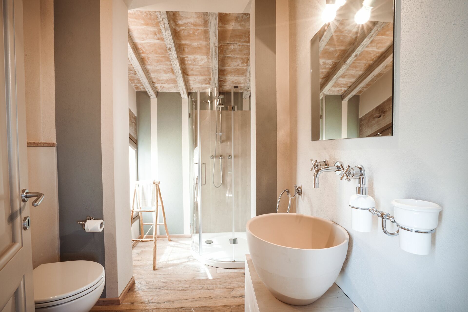 Ein Badezimmer mit einem großen, weißen Waschbecken, einer Dusche und einer Toilette.