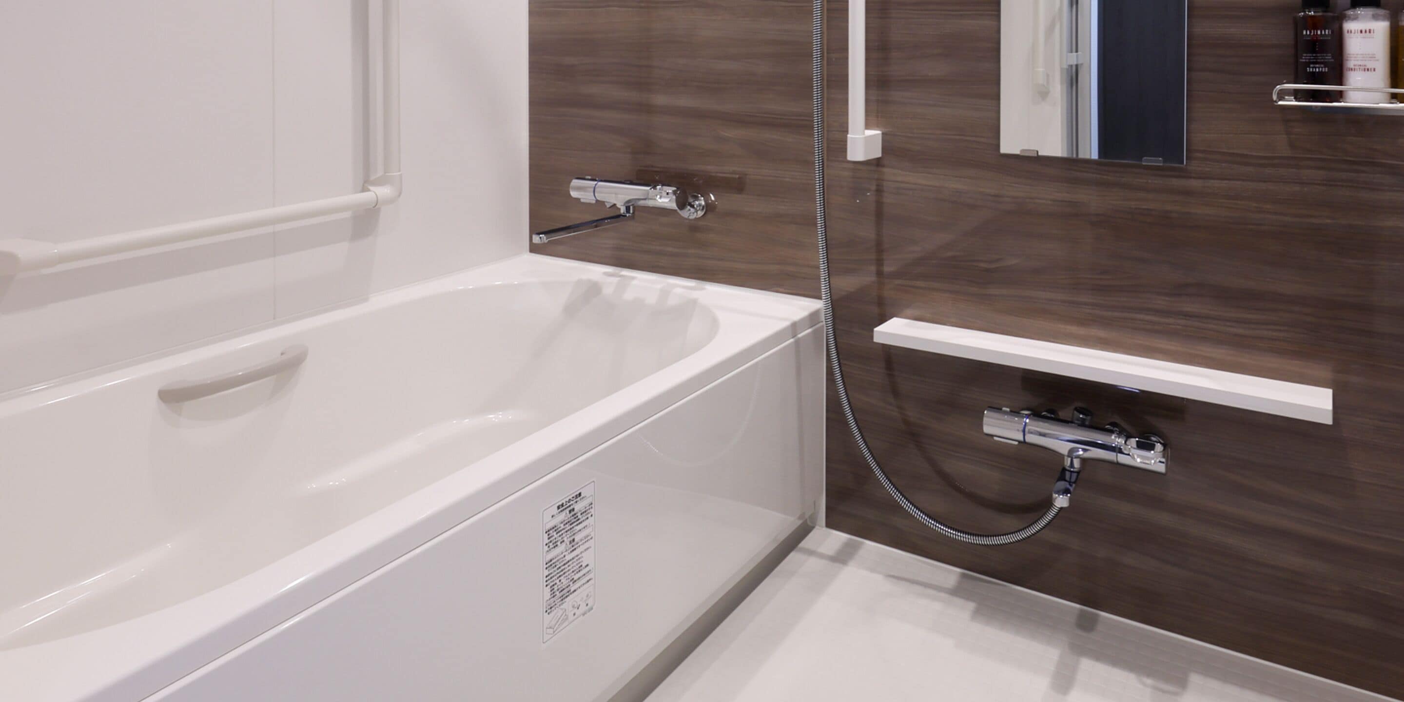 A modern bathroom with a white bathtub, a shower, and a vanity with a mirror.