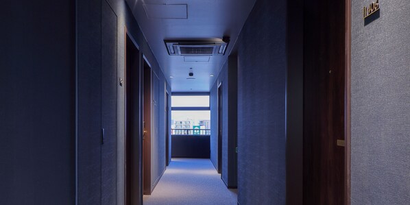 Un couloir d’hôtel donnant sur l’extérieur.