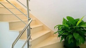 A staircase with a metal handrail and a potted plant on the landing. - Apartment Kola  (Dubrovacko Primorje)