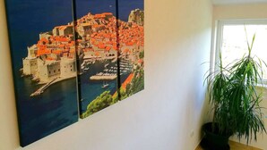 A wall-mounted triptych painting of a coastal town with red-roofed buildings and a harbor. - Apartment Kola  (Dubrovacko Primorje)