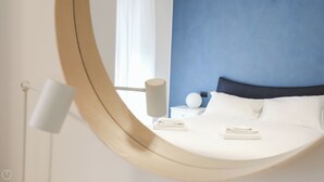 A modern hotel room with a bed, a bedside lamp, and a nightstand with a lamp and a decorative item. - Italianway - Lazzaro Papi 14 B (Milan)