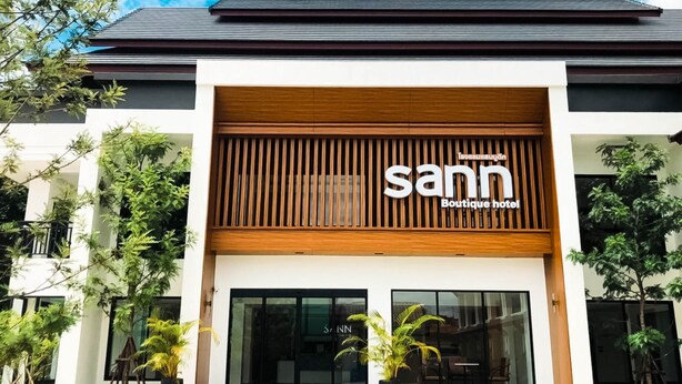 A modern boutique hotel with a prominent 'sann' sign, large glass doors, and a wooden facade. - Sann Boutique Hotel (Chiang Rai)