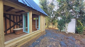 Een houten hut met een veranda, een raam en een deur.