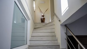 Un escalier en marbre avec un vase placé sur la plateforme.