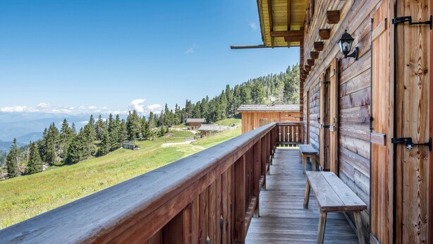 Ein Holzbalkon mit Blick auf eine Berglandschaft.