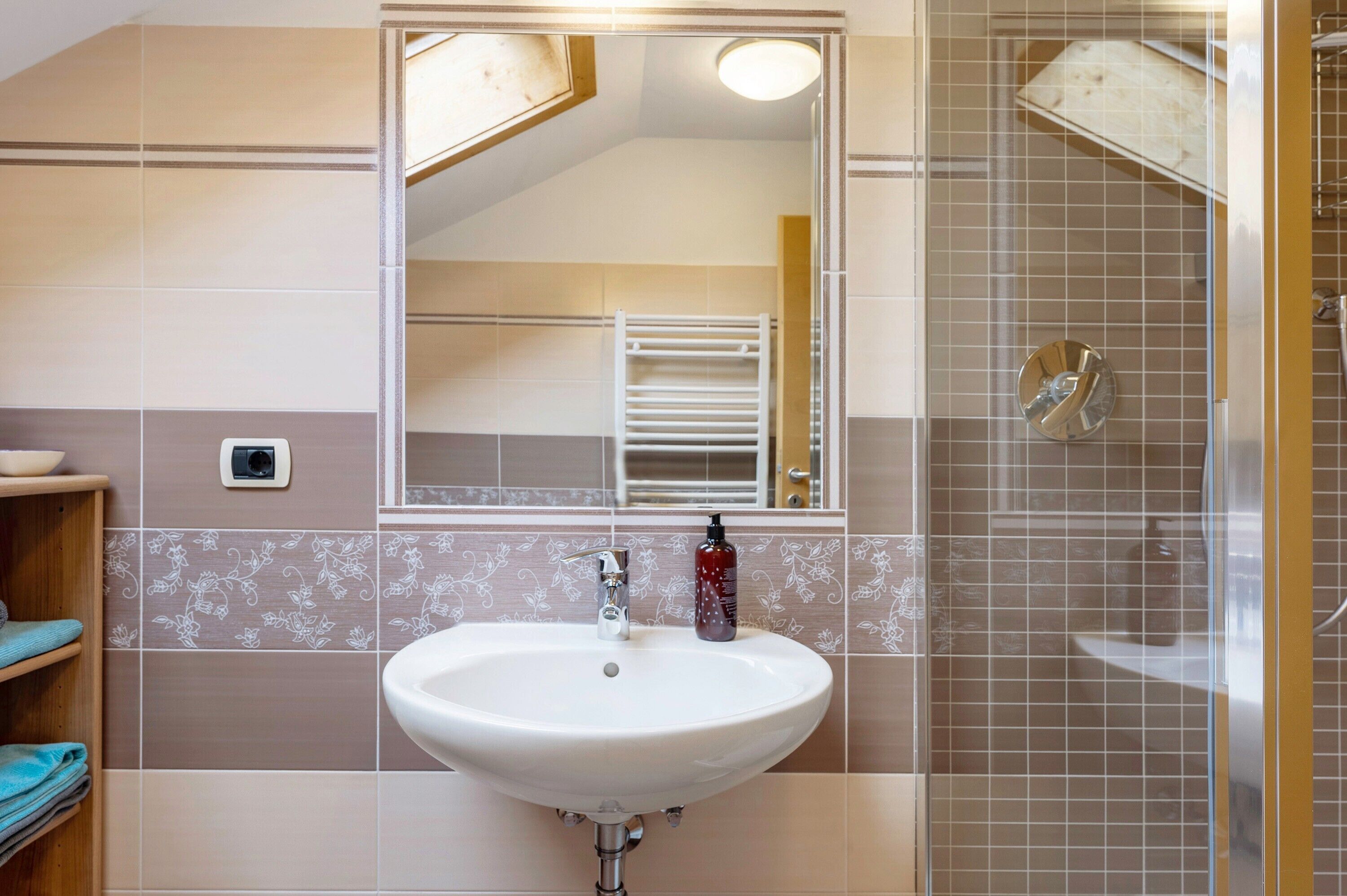 Ein Badezimmer mit Waschbecken, Spiegel und Dusche.