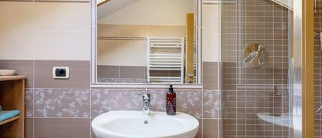 Ein Badezimmer mit Waschbecken, Spiegel und Dusche.