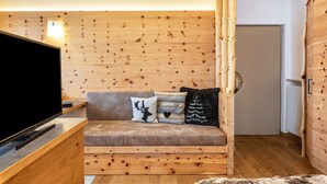 Ein Zimmer mit Holzvertäfelung, einer Couch, einem Fernseher und einer Tür.