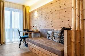 Une pièce chaleureuse avec un mur en bois, un canapé, une table et une chaise.