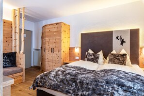Une chambre à coucher avec un lit, une armoire en bois et une décoration murale représentant une tête de cerf.