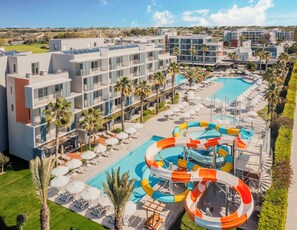 A resort with a swimming pool, water slides, and multiple balconies.