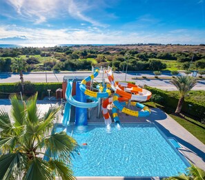 A swimming pool with a water slide and lifeguard stand.