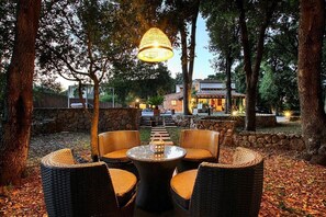 An outdoor seating area with wicker furniture and a hanging light fixture. - Finca "Las Encinas" with Mountain View, Pool, Wi-Fi, Air Conditioning & Garden (Pollensa)