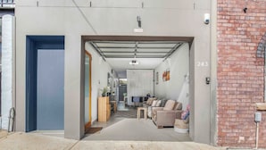 A modern interior with a sofa, a dining table, and a kitchen area. - A Private Garage Suite in Forest Lodge (Forest Lodge)