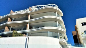 Un immeuble à plusieurs étages, doté de balcons incurvés et de grandes fenêtres.