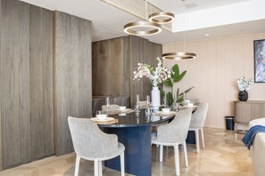 Un comedor moderno con una mesa redonda, sillas y un jarrón con flores.
