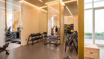 A modern gym with exercise equipment, a mirror, and a view of the outdoors.