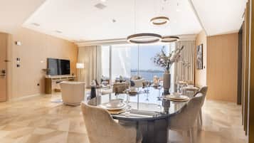 A modern dining area with a glass table, woven chairs, and a view of the city.