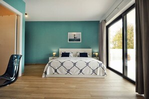 A bedroom with a bed, a chair, a painting on the wall, and a large window. - Modern villa with 4 bedrooms and pool near Pula (Šišan)