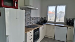 Eine kleine Küche mit Mikrowelle, Backofen, Spüle und Geschirrspüler.