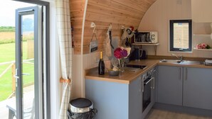A modern kitchen with wooden ceiling, a built-in microwave, and a large window. - 1 bedroom accommodation in Tynely, near Embleton (Tynely, near Embleton)