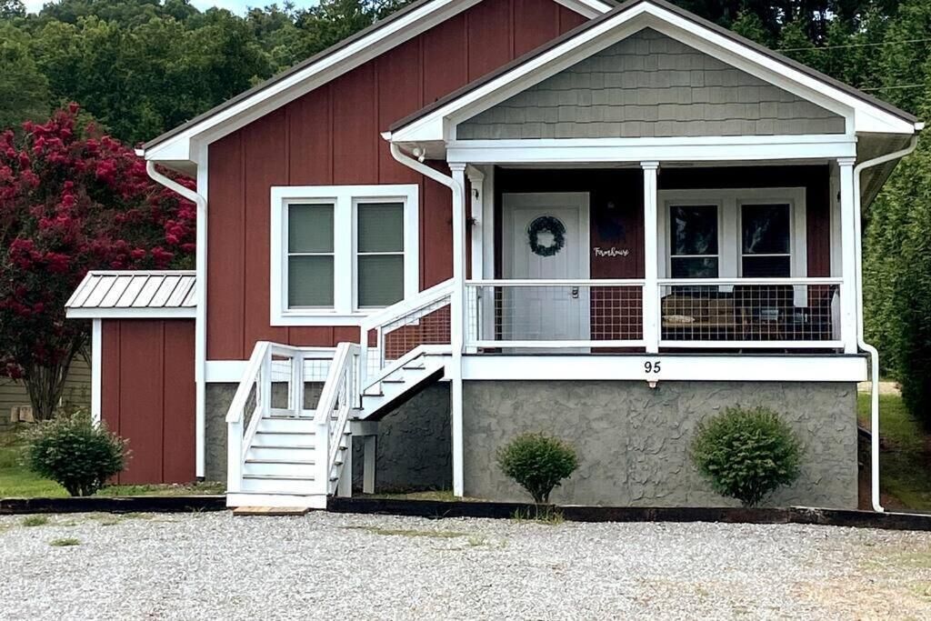 A two-story building with a porch, a staircase, and a door with a wreath.