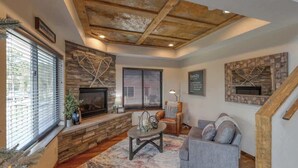 Una sala de estar acogedora con chimenea, pared de piedra y un sofá cómodo.