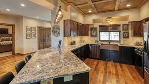 Una cocina moderna con encimeras de granito, armarios de madera y una isla central.