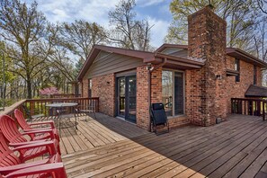 Eine Holzterrasse mit Sitzgelegenheiten und einem Ziegelkamin.