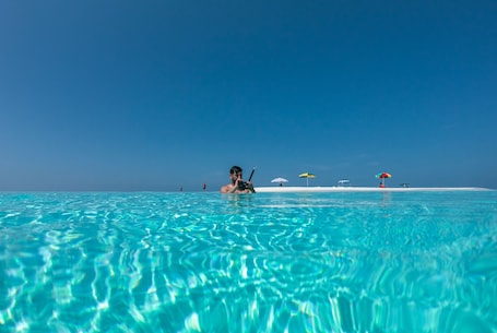 Una playa cerca, arena blanca, sillas reclinables de playa, sombrillas