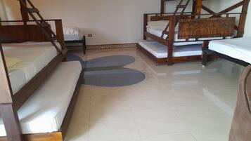 A room with bunk beds, a small table, and a patterned rug.