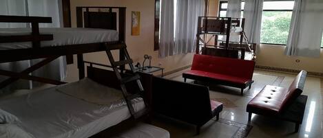 A room with bunk beds, a red sofa, and a small table.