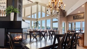 A dining area with a fireplace, a chandelier, and a view of the outdoors. - Allie's - Amazing 8,000 SF Home with --Private Pool--hot tub-- Sleeps 26+  (Sunrise Beach)