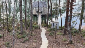 A wooden dock leading to a cabin surrounded by trees. - Beautiful waterfront home on a private cove in Lake Keowee w/ hot tub (Seneca)