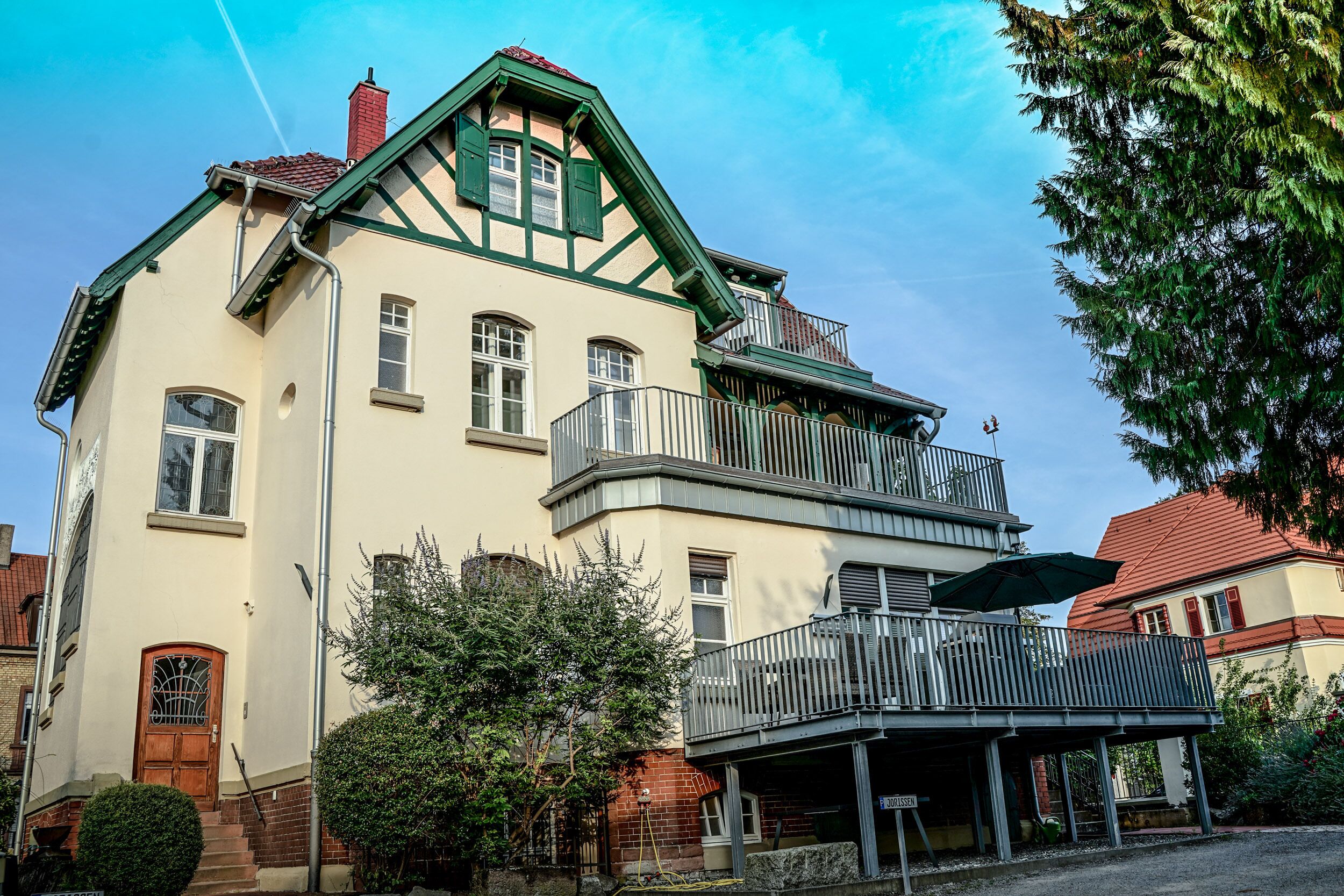 Un bâtiment à deux étages doté d’un balcon et d’une entrée couverte.